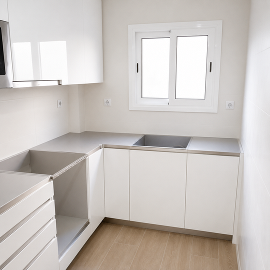 Cocina blanca en U con muebles sin tiradores, encimera gris, cajones y fregadero bajo la ventana