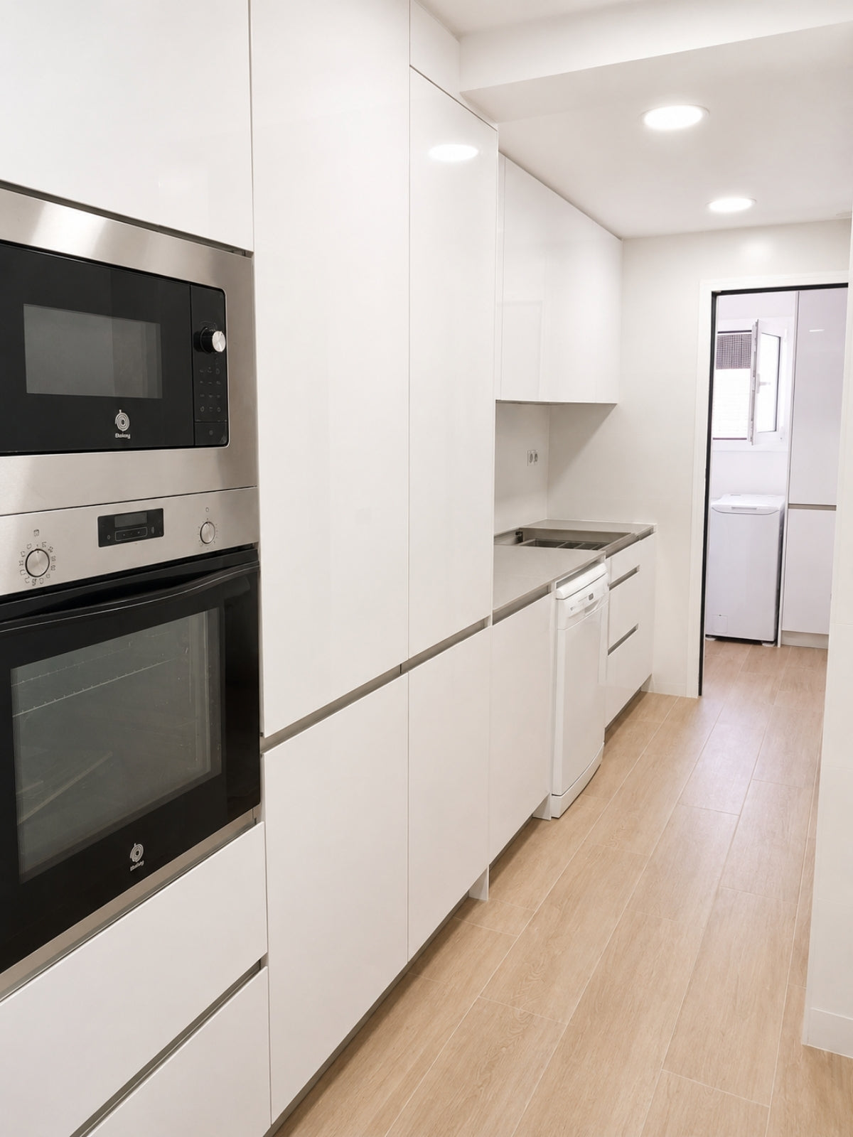 Cocina blanca lineal a medida con electrodomésticos integrados en Vilassar de Mar