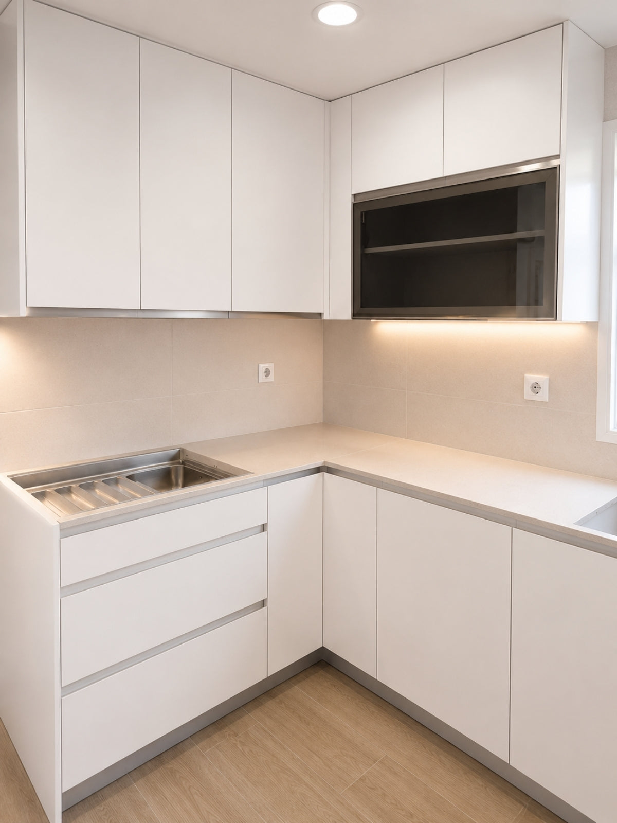 Cocina blanca minimalista en L a medida en Alella