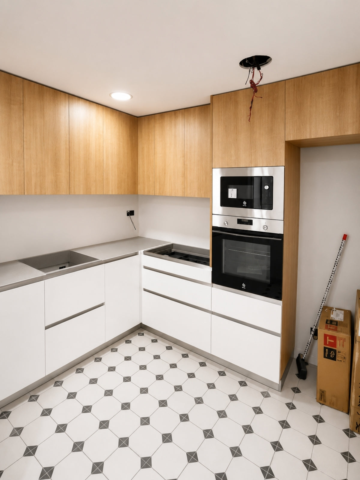 Cocina blanca y madera en L a medida con torre de horno en Sant Vicenç de Montalt
