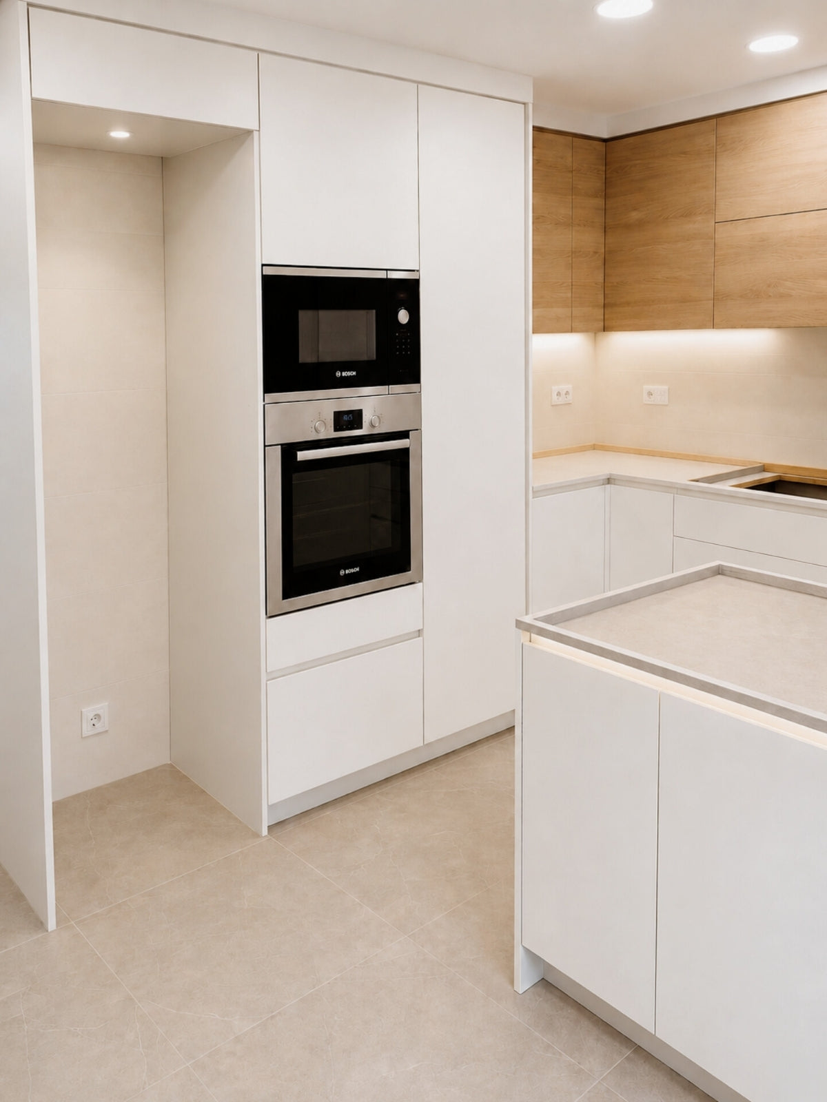 Cocina blanca y madera en U a medida con torre de horno en Sant Vicenç de Montalt