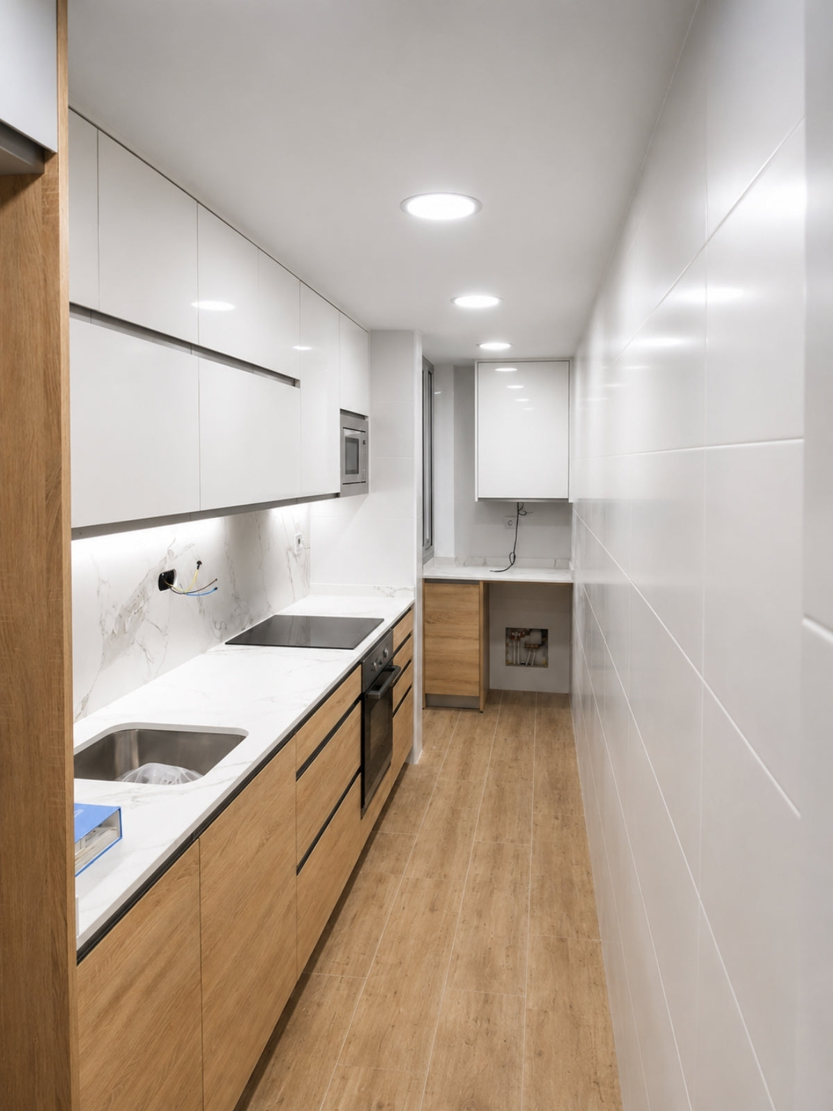 Cocina blanca y madera a medida de distribución lineal en Vilassar de Mar