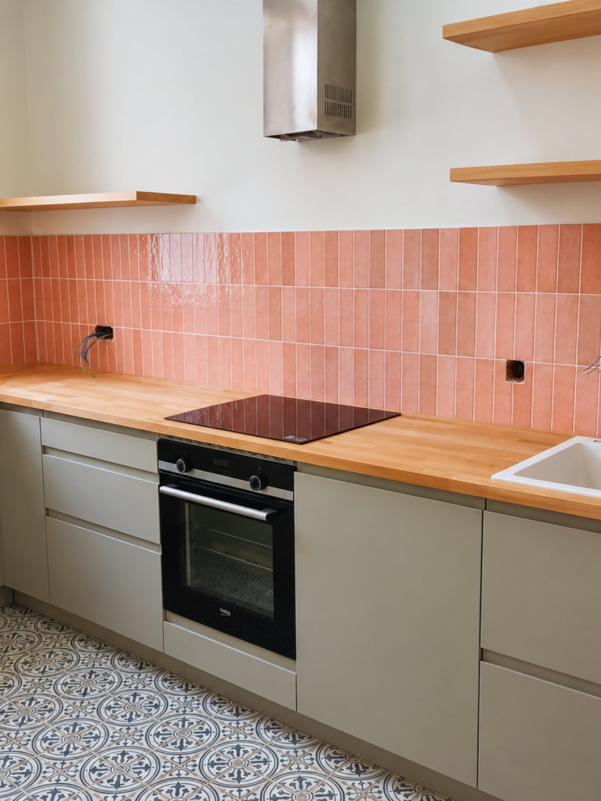 Cocina gris a medida con encimera de madera y azulejo decorativo en Arenys de Mar