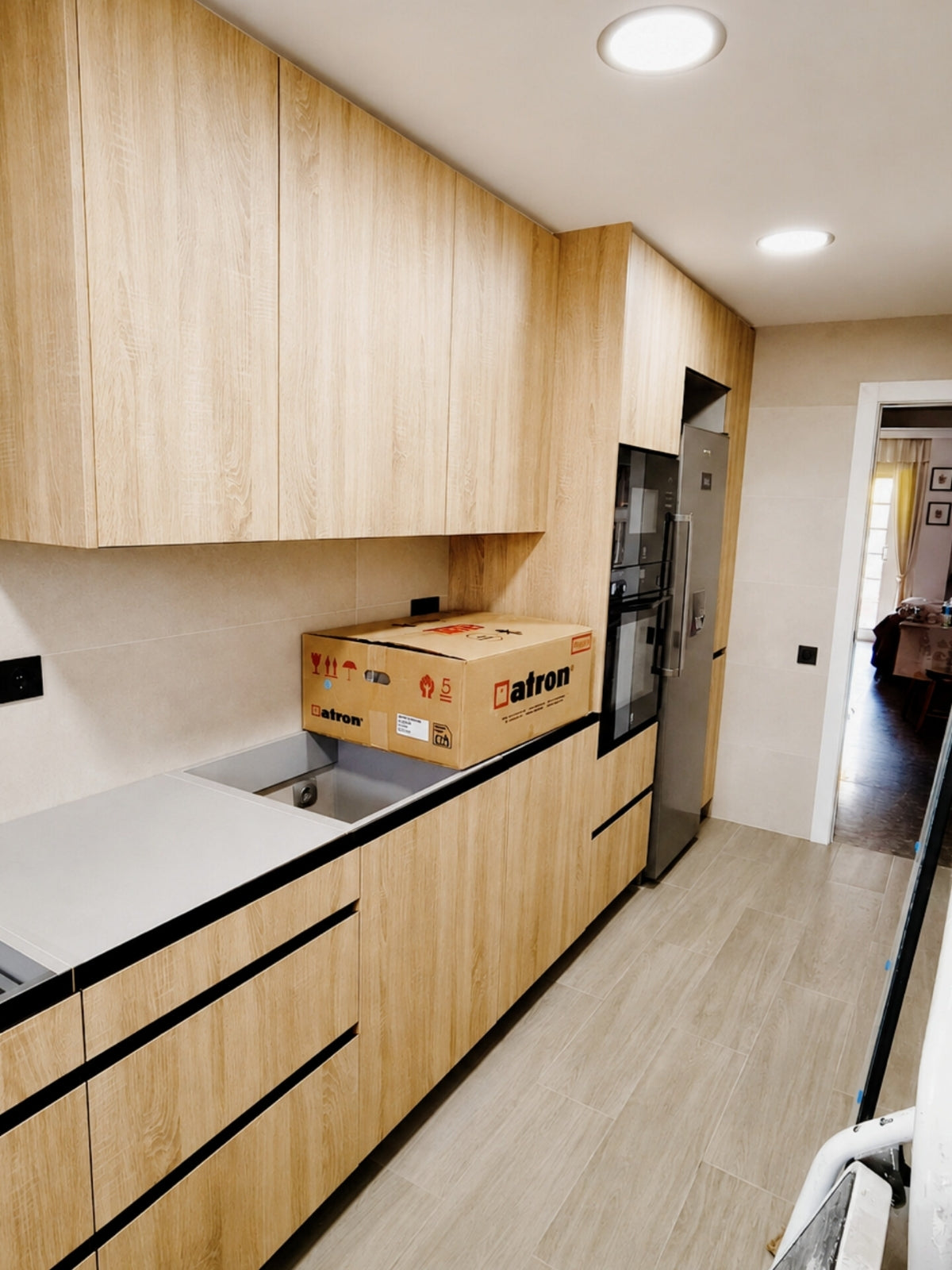 Cocina lineal de madera clara a medida con gran capacidad de almacenaje en El Masnou
