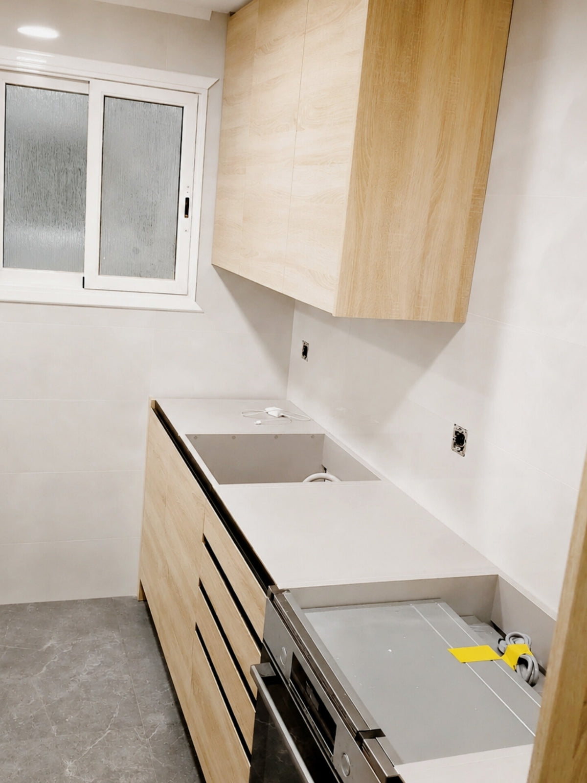 Cocina de madera a medida con encimera oscura en Santa Coloma de Gramenet