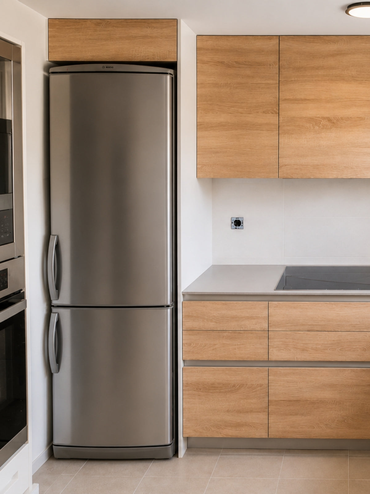 Cocina de madera a medida con frigorífico inoxidable en Arenys de Mar