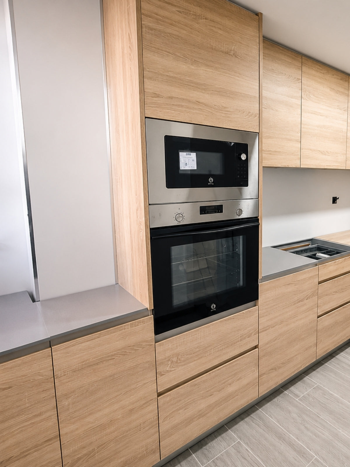 Cocina de madera a medida con torre de horno y microondas en Vilassar de Mar