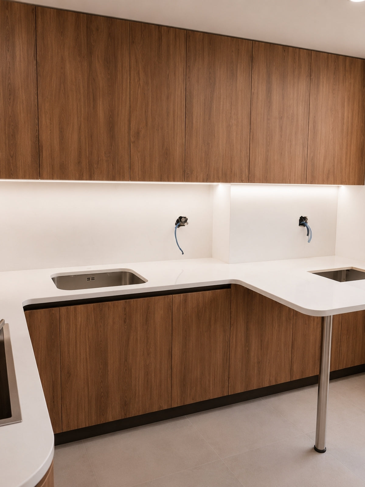 Cocina de madera en U a medida con encimera blanca en Vilassar de Mar