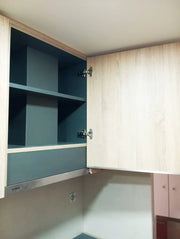 Puerta de cocina a medida en acabado madera instalada en un mueble alto.