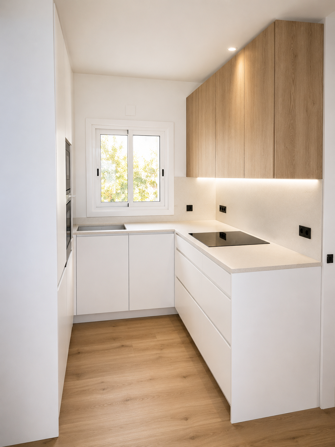 Cocina estrecha en U con muebles blancos, armarios altos de madera, encimera clara e iluminación LED